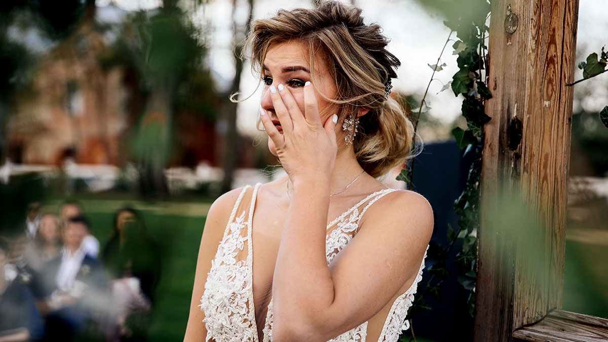 Bride horrified and emotional at outdoor wedding, reacting to cousin wearing long white dress approved by her mom.