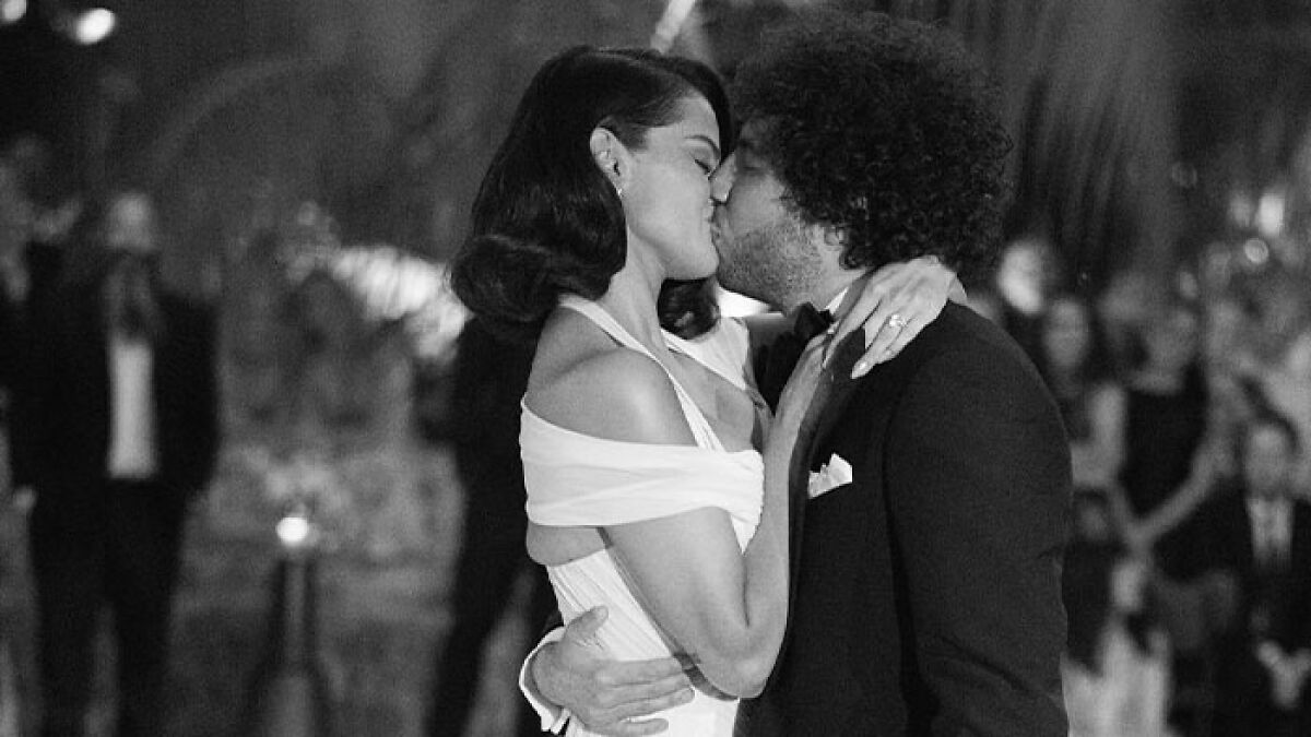 Selena Gomez and Benny Blanco share a kiss at their modern fairytale princess wedding reception in an elegant setting.