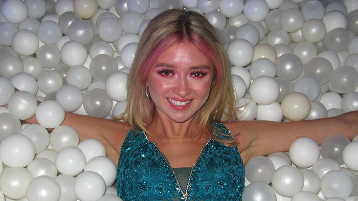 Young woman smiling in a blue dress surrounded by white plastic balls, highlighting coroner report on refusing chemo.