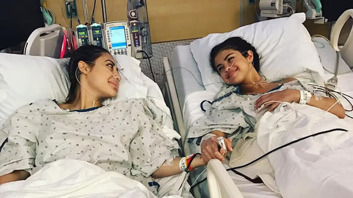 Selena Gomez and kidney donor woman holding hands in hospital beds after kidney transplant surgery.
