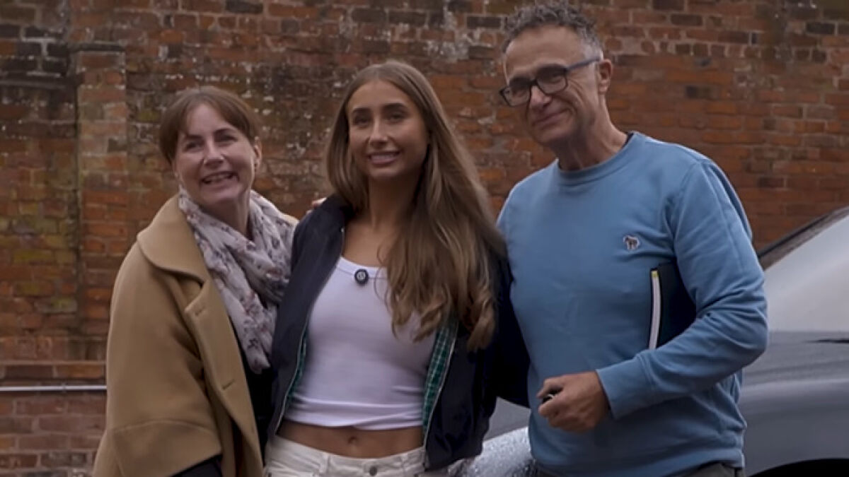 Lily Phillips with two people outside against a brick wall, discussing her fame and the love of money story.