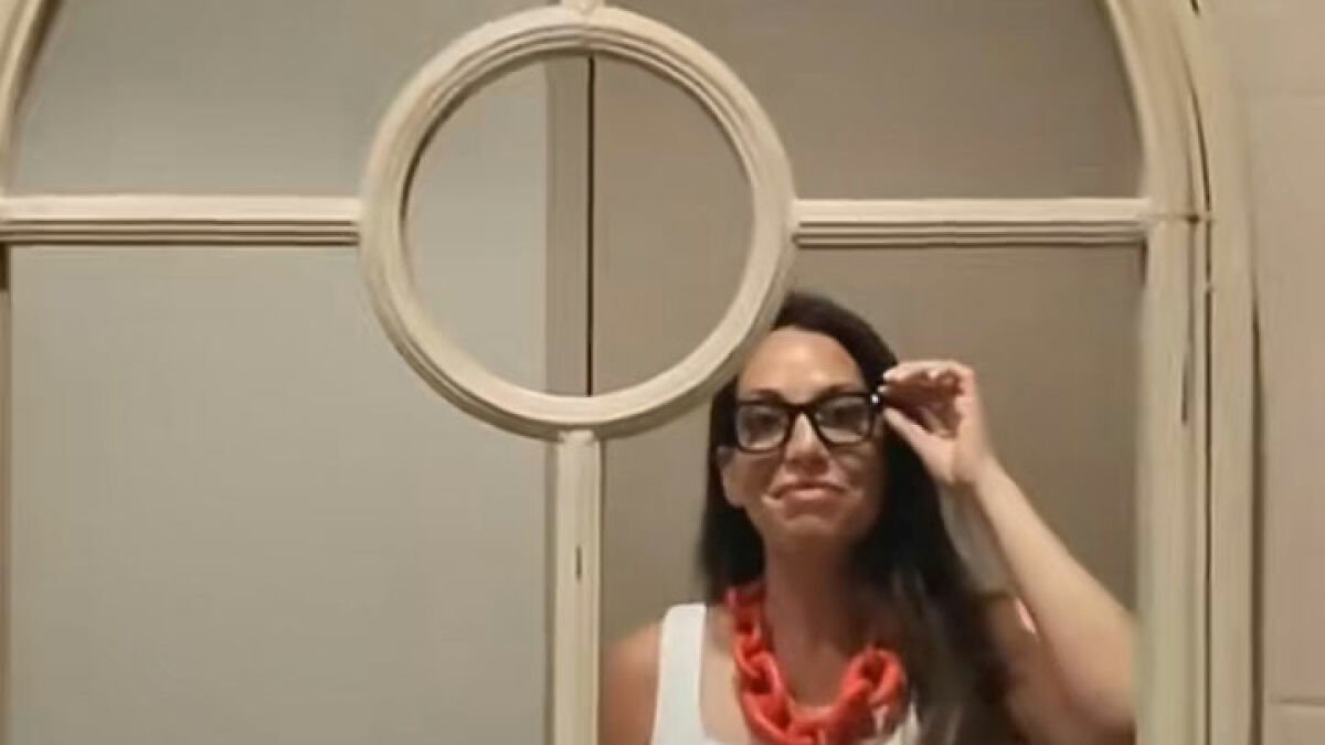 Woman wearing glasses adjusting them, reflecting on vacation regrets recorded with Meta glasses footage.