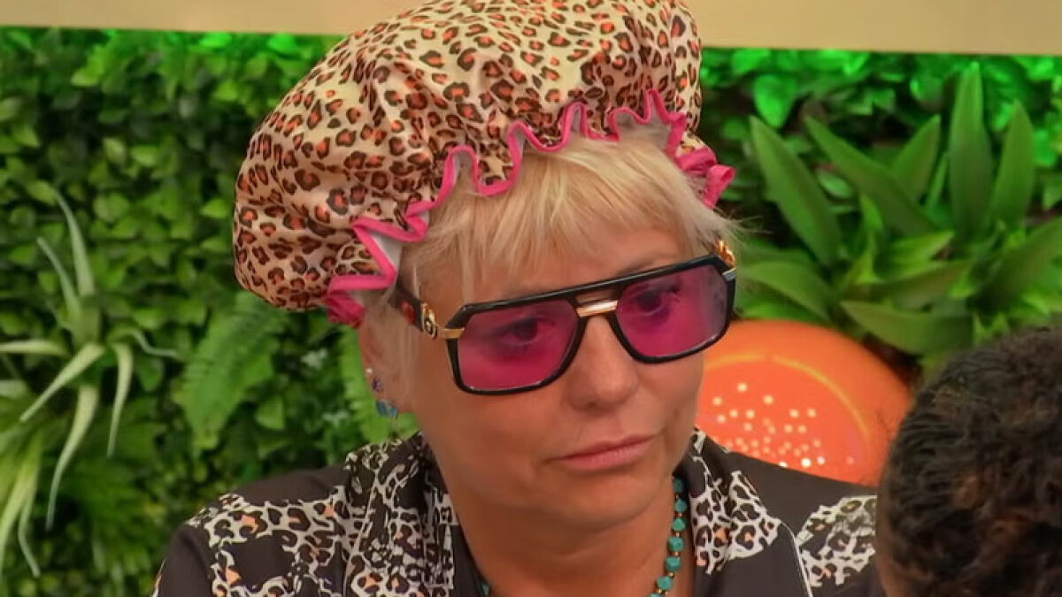 Housemate wearing leopard print shower cap and pink sunglasses, Big Brother fans demand immediate exit after uncomfortable moment.