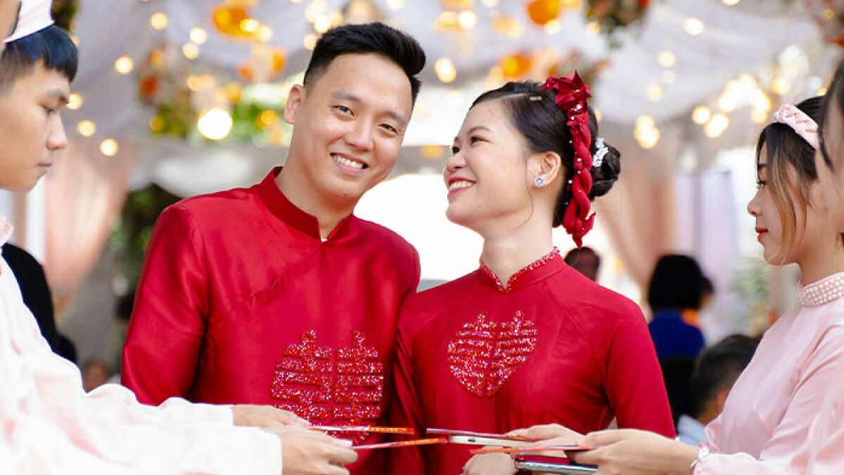 Bridesmaids and wedding guests in traditional attire during a joyful ceremony with decorative lights in the background