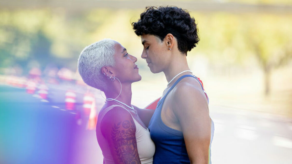 Two women embracing outdoors, representing the LGBTQ community amid controversy over men-only gay bar and misogyny claims.