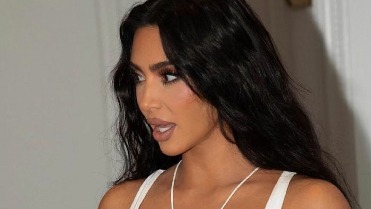 Kim Kardashian with dark hair and makeup, pictured indoors, related to wig for private parts and intimate underwear line.
