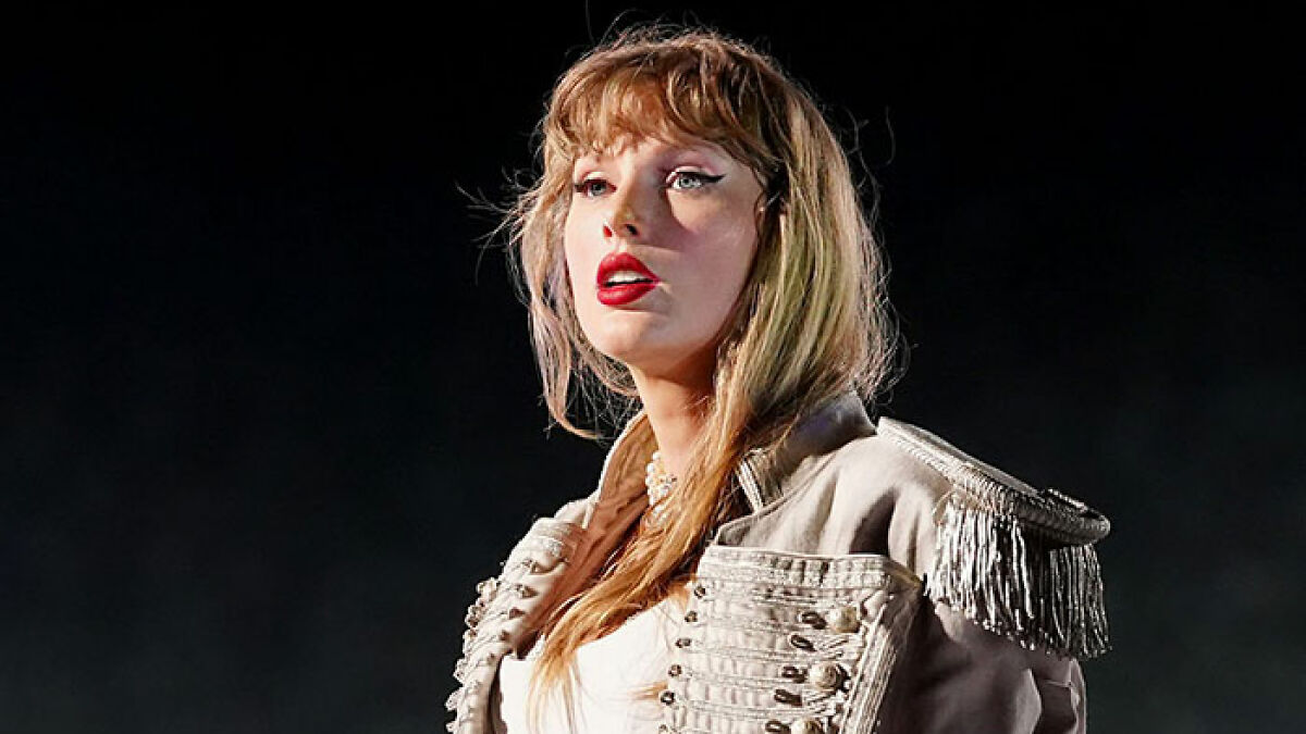 Taylor Swift performing live on stage with bold red lipstick, highlighting mom of late friend breaking silence after 15 years.