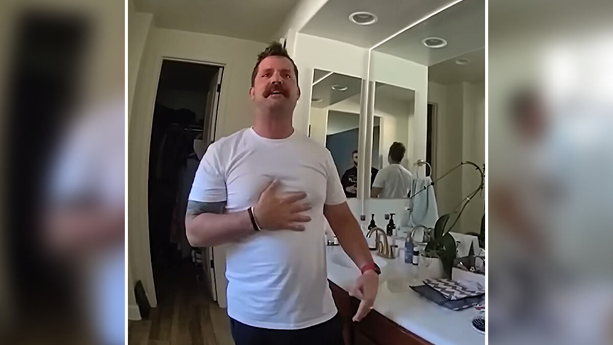 Man in white t-shirt standing in bathroom with mirror, related to dad watched adult videos and child hot car case.