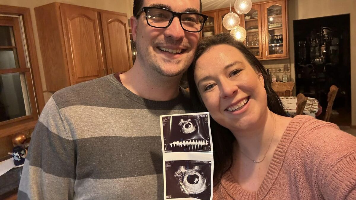 Couple happily posing in a kitchen while holding ultrasound images, related to Disney superfan life update.