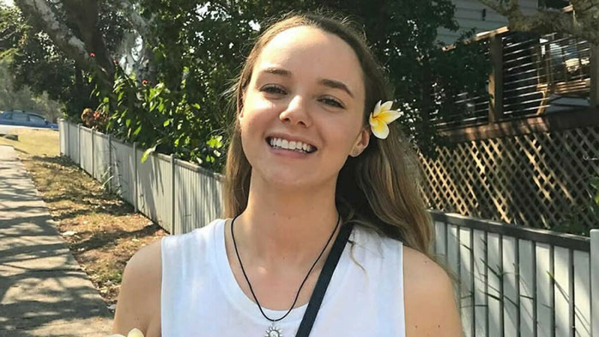Young nutritionist and influencer Stacey Hatfield smiling outdoors with a flower in her hair, expressing warmth and positivity.