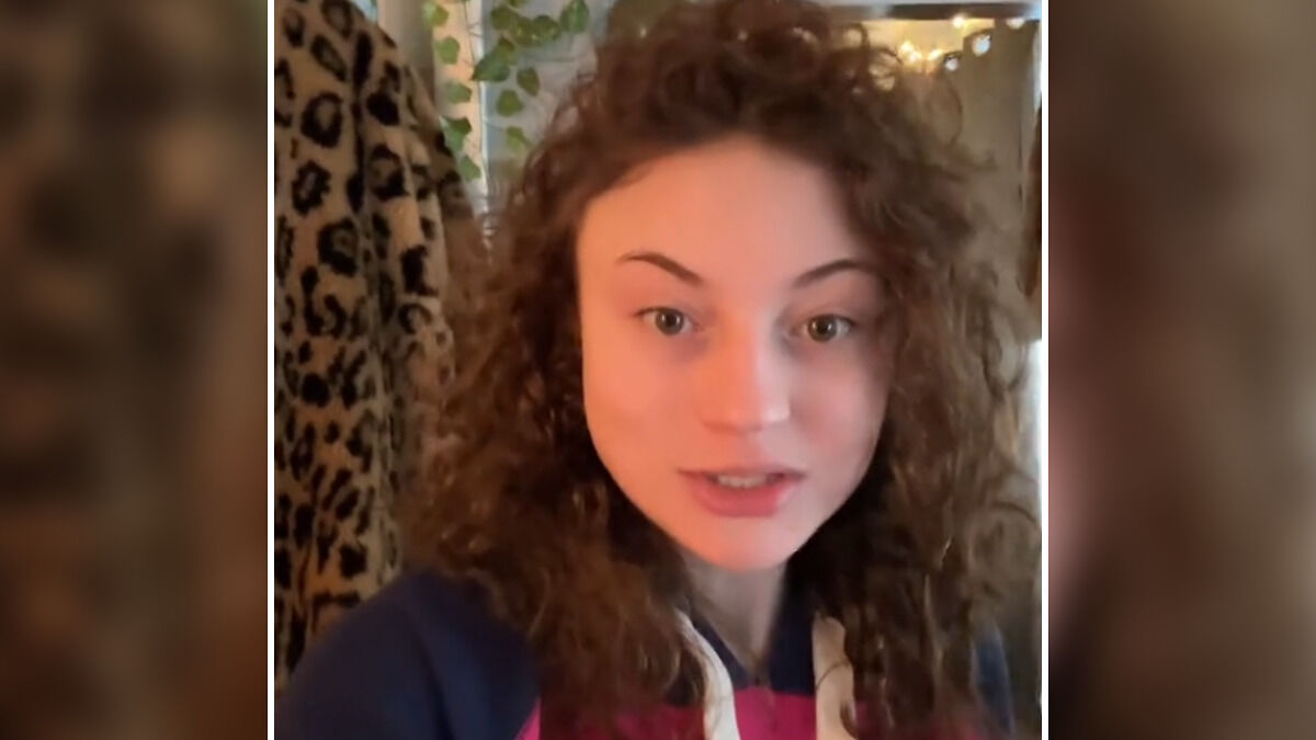 Woman with curly hair speaking in a casual indoor setting about customer exposure and firing controversy debate.