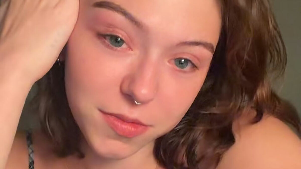 Young woman with nose ring looking thoughtful in a close-up portrait about viral removal after men's comments.