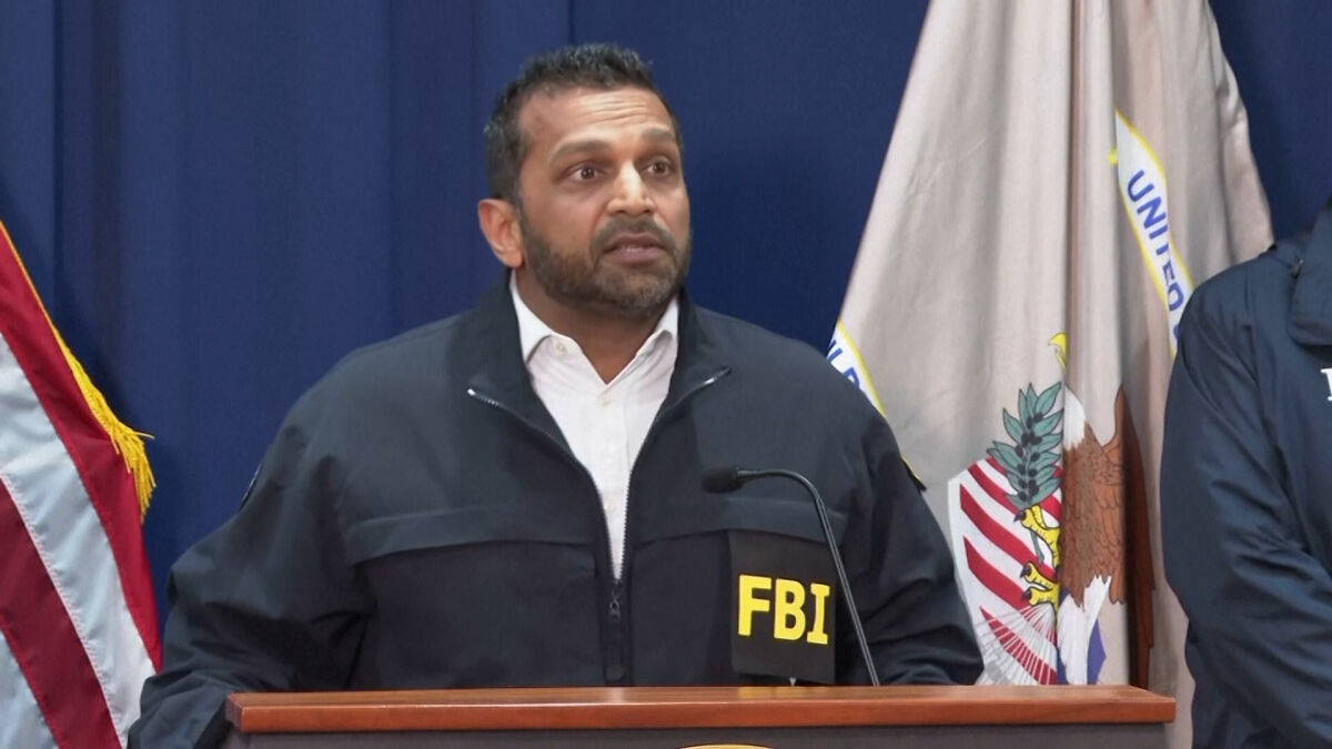 FBI agent in uniform speaking at a podium during press briefing on NBA gambling scandal investigation details.