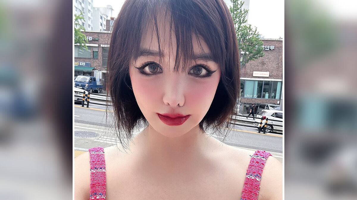 K-Pop icon Park Bom with bold makeup and short hair outdoors, highlighting her drastic plastic surgery transformation.