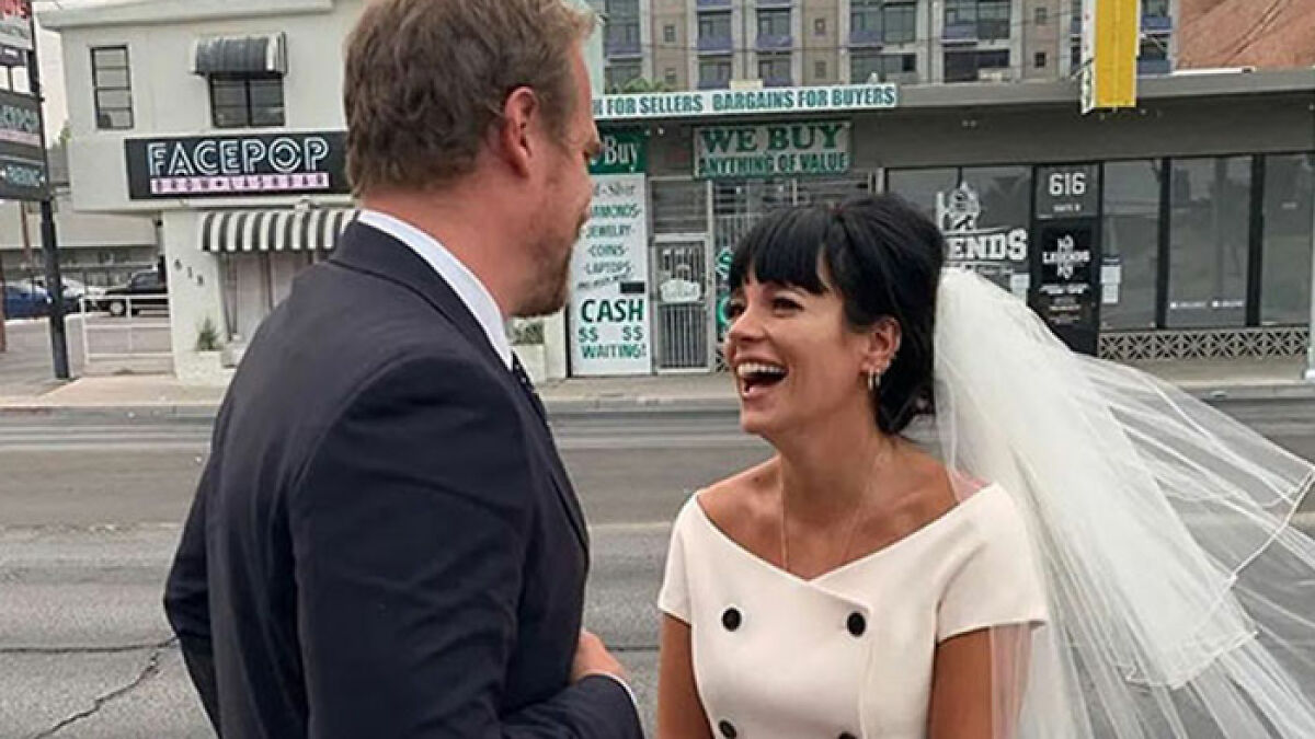 Bride laughing with groom on city street, featuring mystery woman at center of Lily Allen and David Harbour cheating rumors