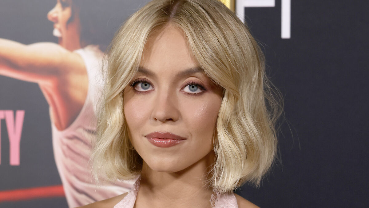 Sydney Sweeney with blonde hair and subtle makeup at an event, showcasing her latest transformation and embracing MAGA style.