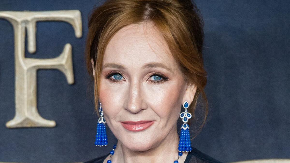 J.K. Rowling with blue earrings and necklace, posing at an event, related to reactions on Glamour UK Women of the Year.