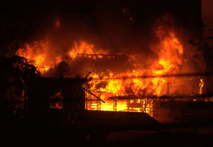 Intense fire engulfing a building at night, evoking the creepiest found footage and videos ever seen.