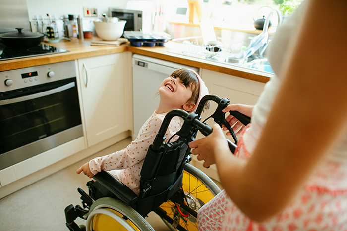Young woman preparing to become caregiver for disabled stepsister in a bright kitchen, showing care and support.