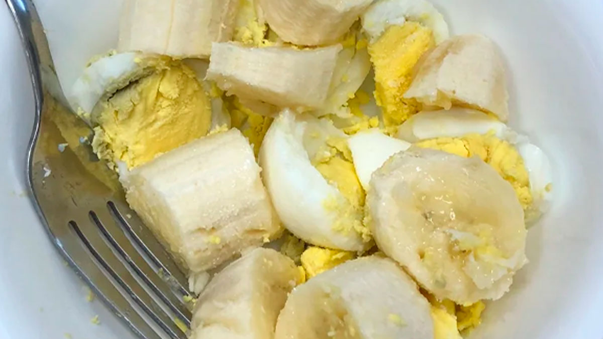 Bowl of sliced banana and hard-boiled egg pieces with a fork, showcasing cursed and disgusting food combination.