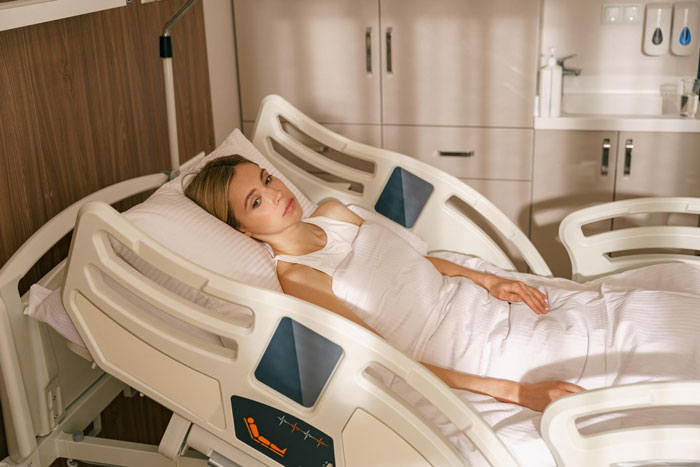 Woman lying in a hospital bed looking concerned while waiting during a family emergency with a boy’s trip affair disguise. Woman lying in a hospital bed looking concerned while waiting during a family emergency with a boy’s trip affair disguise.
