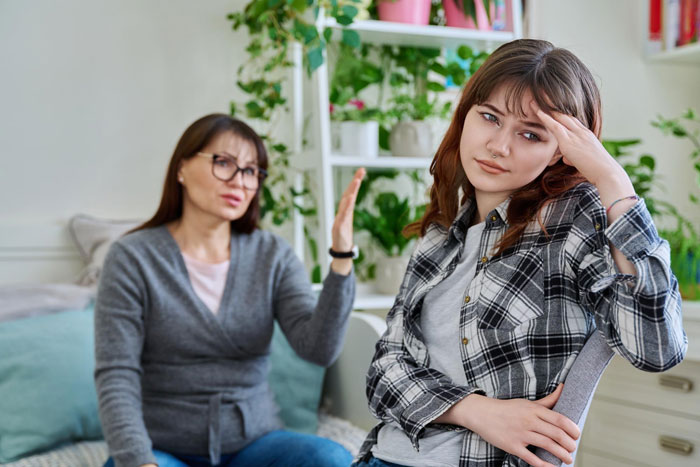 Woman obsessed with being bonus mom looks crushed as stepdaughter expresses frustration during a tense conversation at home. Woman obsessed with being bonus mom looks crushed as stepdaughter expresses frustration during a tense conversation at home.