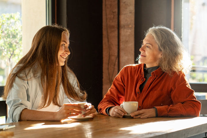 Woman and stepdaughter having a heartfelt conversation over coffee, reflecting on the bonus mom and mom roles. Woman and stepdaughter having a heartfelt conversation over coffee, reflecting on the bonus mom and mom roles.