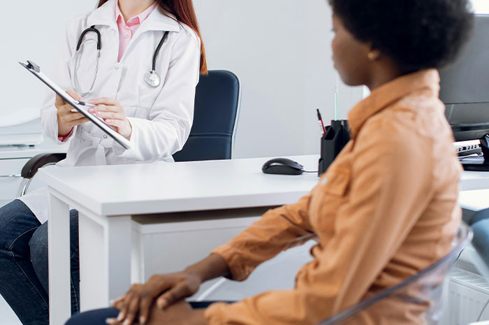 Doctor consulting patient in office after symptoms googling, discussing medical concerns before seeing a healthcare professional.