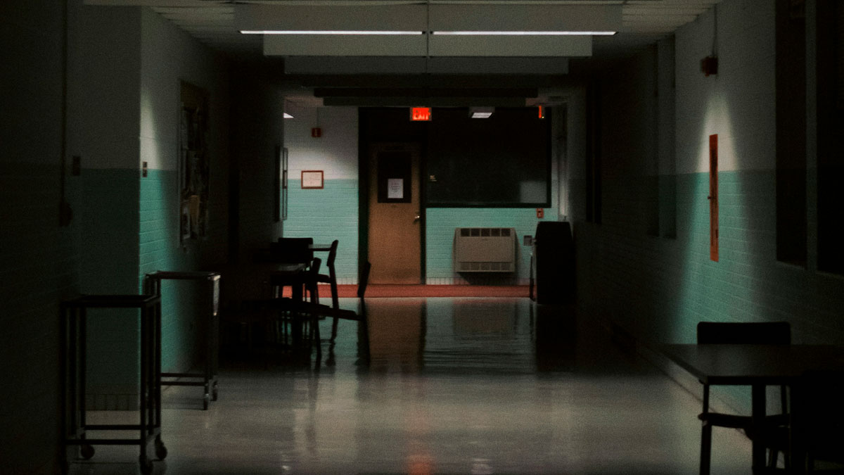 Dimly lit hospital hallway with scattered chairs and tables, evoking the creepiest experiences hospital workers face.