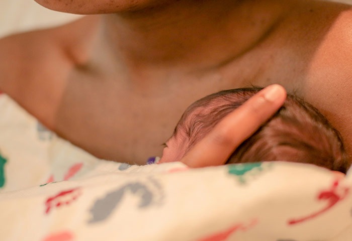 Newborn cradled against mother's chest, illustrating a moment related to birth meltdowns witnessed by doctors.