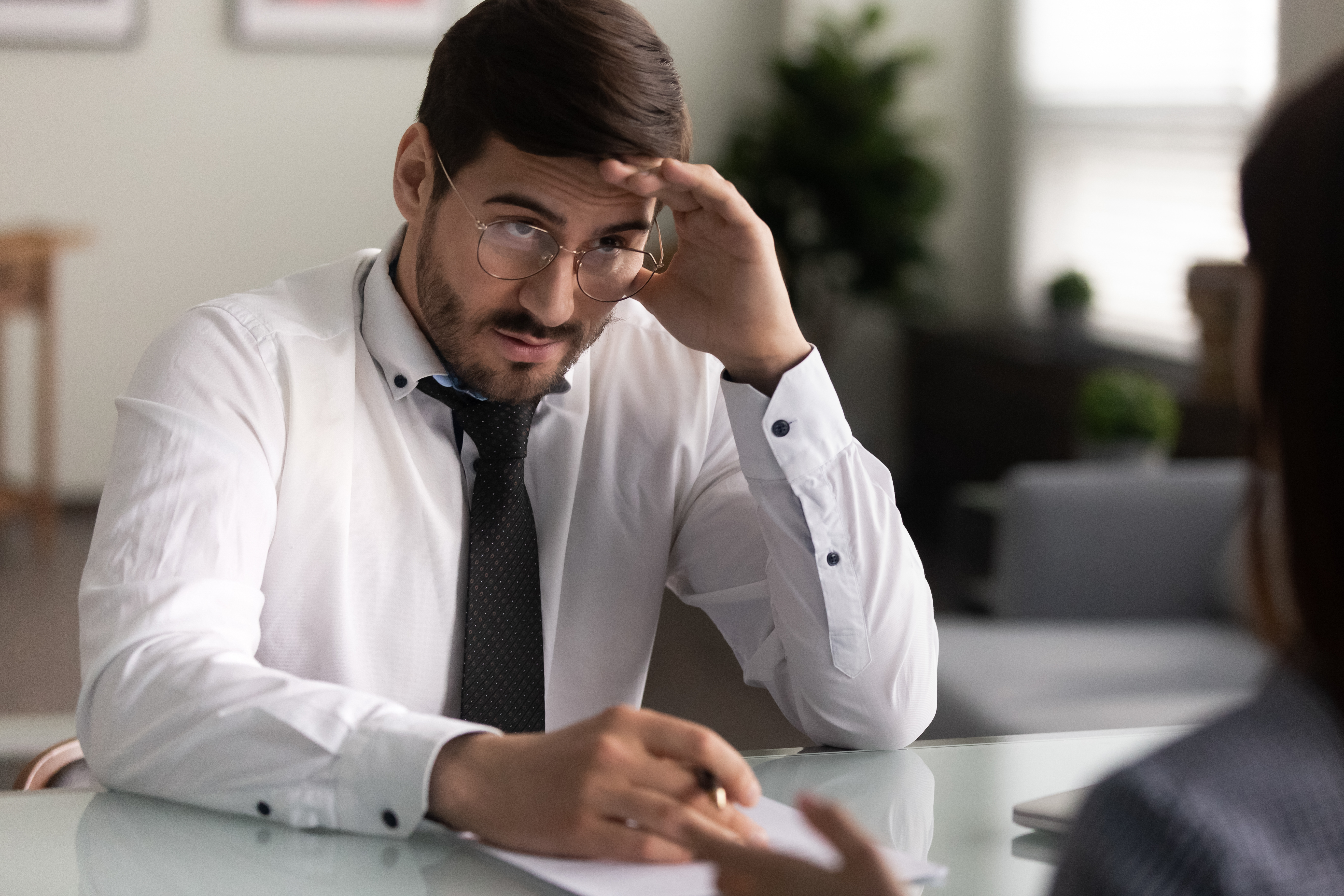 Man in white shirt and glasses interviewing a candidate, discussing job offers and name change impact. Man in white shirt and glasses interviewing a candidate, discussing job offers and name change impact.