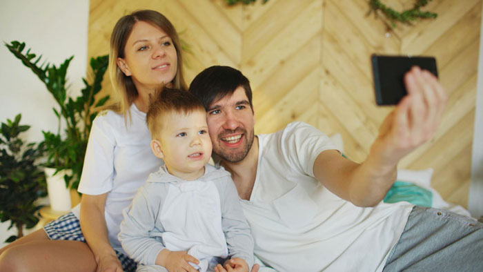Family taking a selfie at home, illustrating themes of wife cheats and new life with lover while husband moves on. Family taking a selfie at home, illustrating themes of wife cheats and new life with lover while husband moves on.