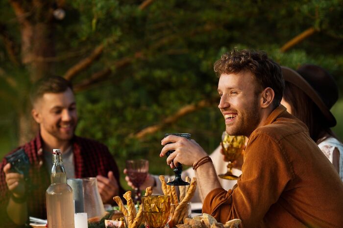 Group of friends enjoying a meal outdoors, highlighting cancer survivors sharing unexpected symptoms that prompted doctor visits.