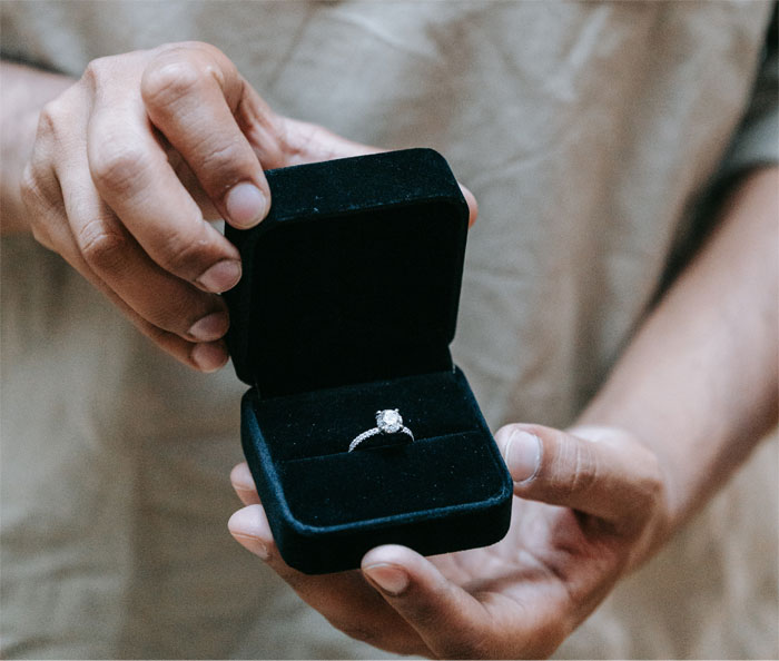 Hands holding a black velvet box with a diamond ring, symbolizing a family heirloom involved in a legal dispute. Hands holding a black velvet box with a diamond ring, symbolizing a family heirloom involved in a legal dispute.