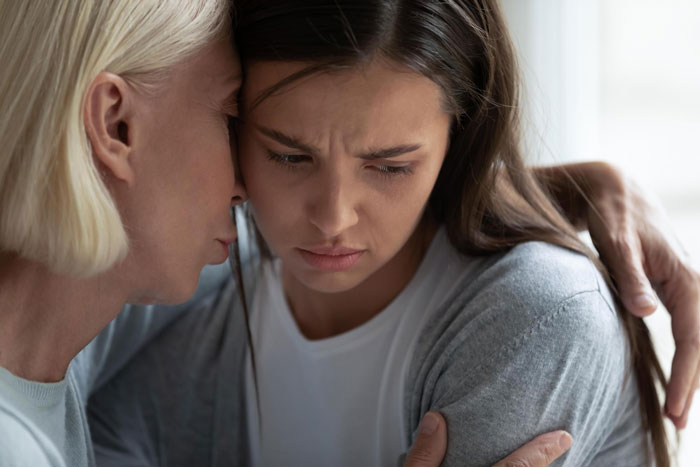 Mother comforting upset daughter, showing regret and emotional connection in a heartfelt family moment. Mother comforting upset daughter, showing regret and emotional connection in a heartfelt family moment.