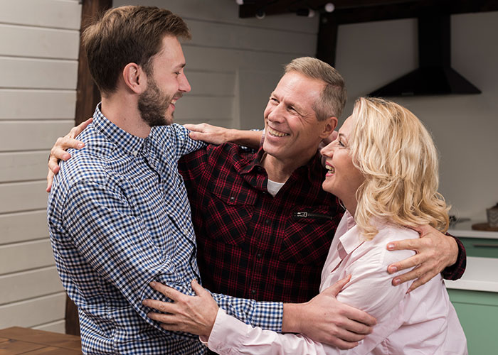 Three family members warmly embracing and smiling, preparing for a separate drive to Disneyland together. Three family members warmly embracing and smiling, preparing for a separate drive to Disneyland together.