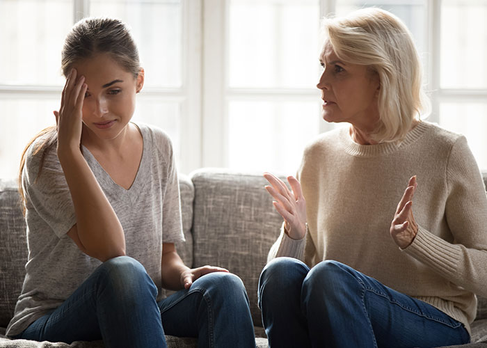 Two women having a serious conversation at home, illustrating family separate drive Disneyland challenges and emotions. Two women having a serious conversation at home, illustrating family separate drive Disneyland challenges and emotions.