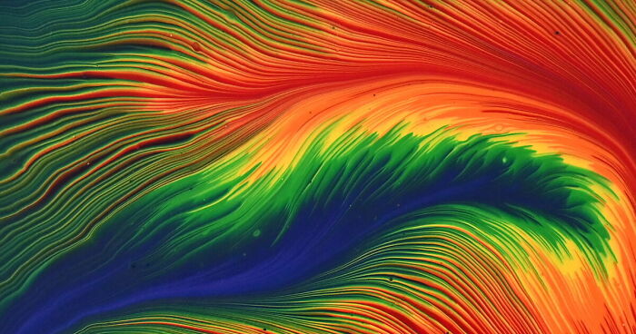 Vibrant electric rainbow feathers in a split cup acrylic pour painting with flowing, textured patterns and bold colors.