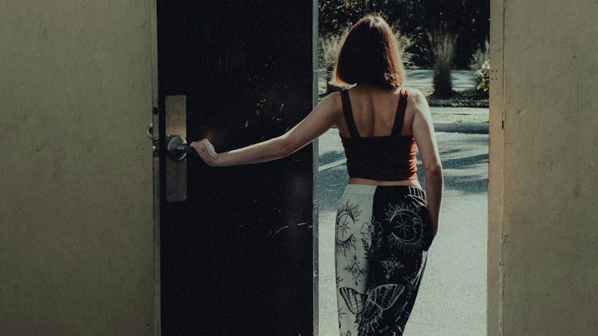 Woman opening door and walking outside, symbolizing heartbreaking things committed by close friends that broke trust forever.