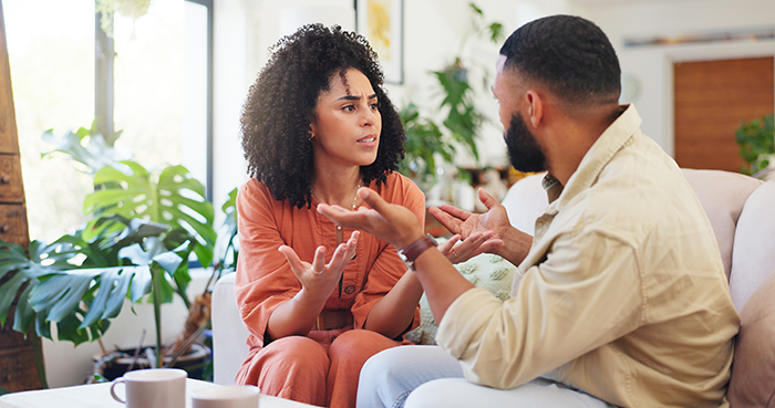 Woman and man having a serious conversation indoors, depicting a tense moment related to autistic child and work trip vacation. Woman and man having a serious conversation indoors, depicting a tense moment related to autistic child and work trip vacation.