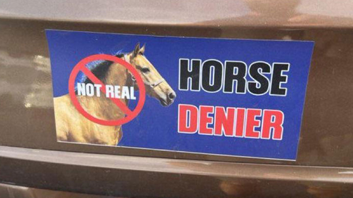 Funny bumper sticker on a car reading horse denier with a horse image and not real crossed out symbol.