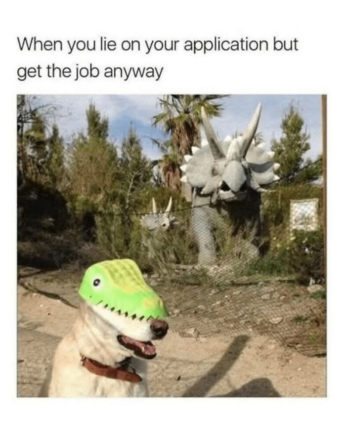 Dog wearing a dinosaur mask, humorously fitting with dinosaur statues in the background, in wholesome animal memes style.