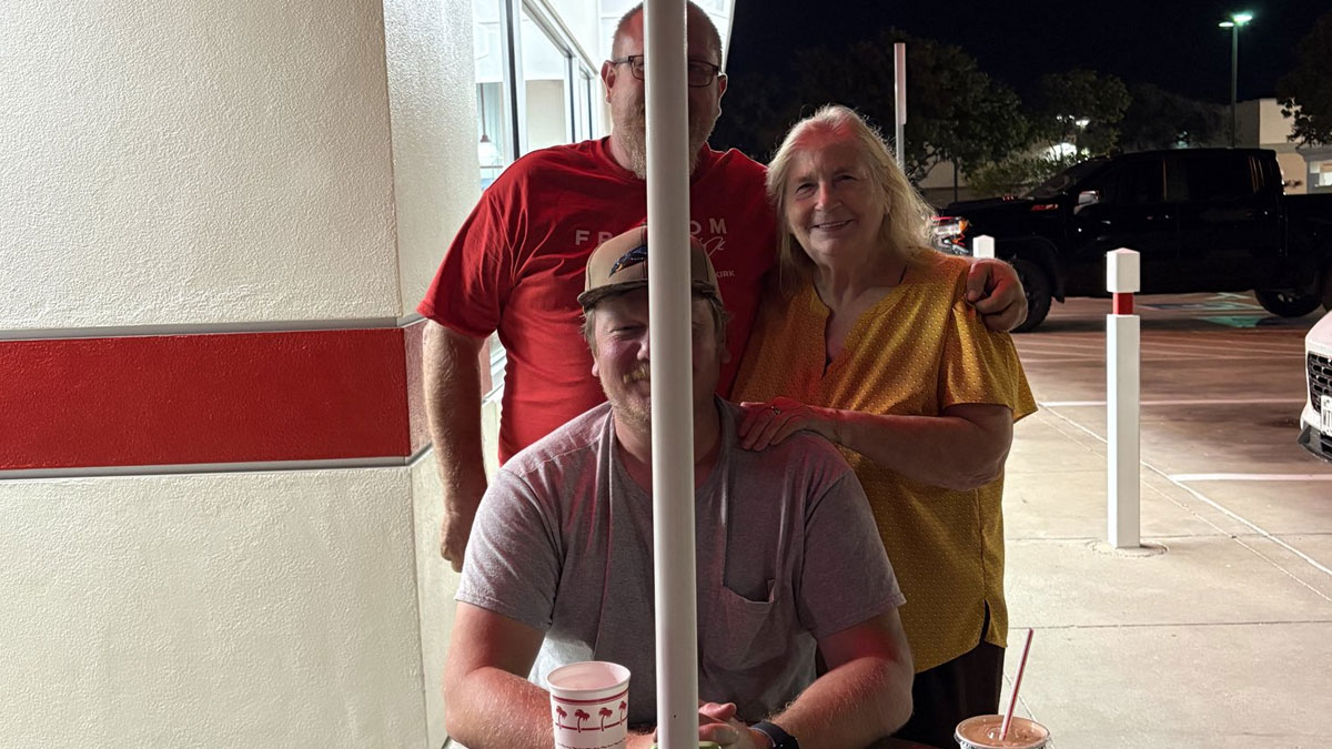 Three people at an outdoor table at night with drinks, illustrating Netflix gotta add a comment section humor in tweets.