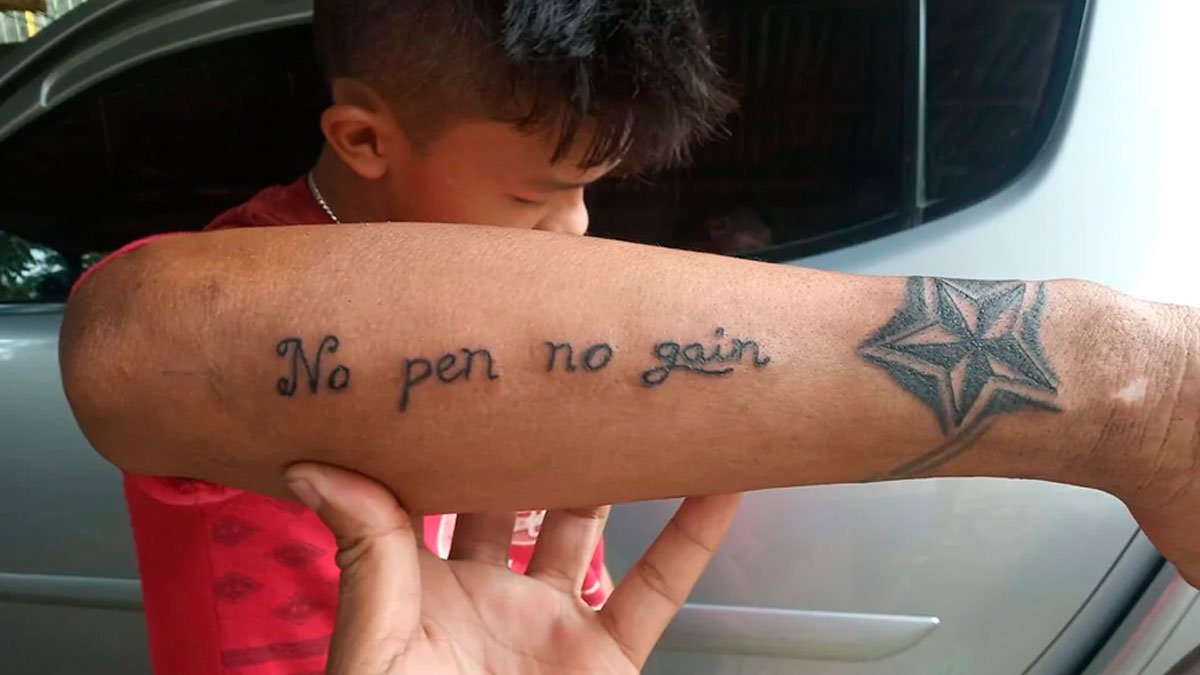 Tattoo fail on forearm with misspelled phrase no pen no gain and a star design near wrist.