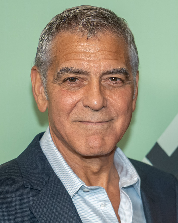 George Clooney posing in a suit jacket and open-collar shirt amid controversy over Virginia Giuffre Epstein memoir allegations.