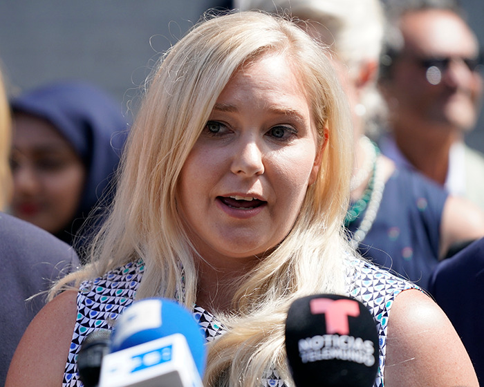 Virginia Giuffre speaking to reporters outdoors, with microphones in front, amid George Clooney Epstein allegation news.