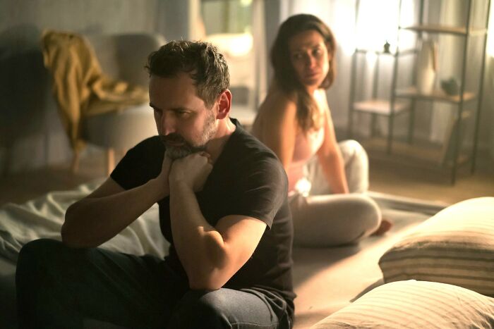 Black lace lingerie on white bed sheets symbolizing cheating signs in women shared by broken-hearted men.