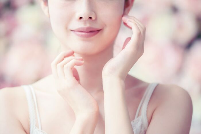 Close-up of a serene woman gently touching her face, symbolizing the unsettling nature of disturbing things people realize later.