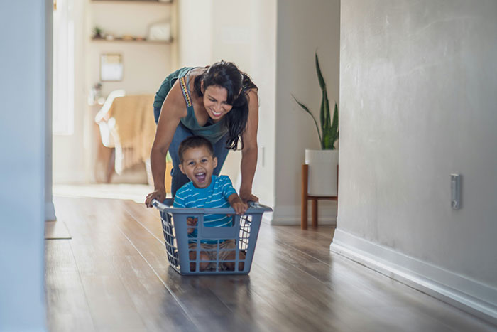 Young woman caring for toddler in laundry basket, illustrating mom abandonment and sibling caregiving themes. Young woman caring for toddler in laundry basket, illustrating mom abandonment and sibling caregiving themes.
