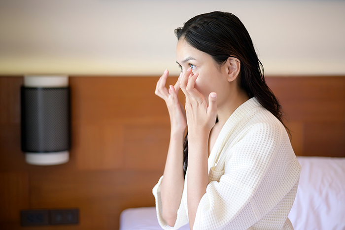Woman in a robe wiping tears in a bedroom, reflecting emotional reaction to open marriage proposal twist. Woman in a robe wiping tears in a bedroom, reflecting emotional reaction to open marriage proposal twist.